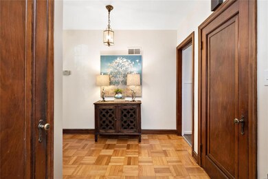 foyer with parquet wood floors. half bath is off the foyer