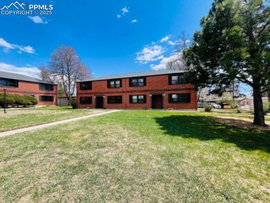 View of front of home with a front yard and brick 