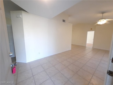 Empty room with light tile patterned floors, a cei