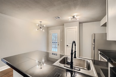 Kitchen with visible vents, an inviting chandelie