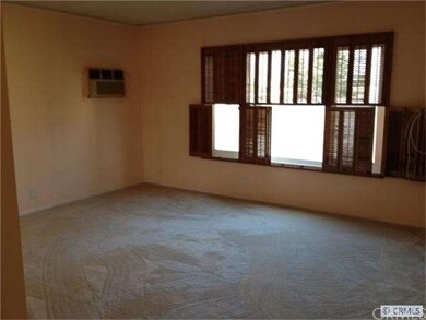 Master bedroom with wood shutters and wall A/C.
