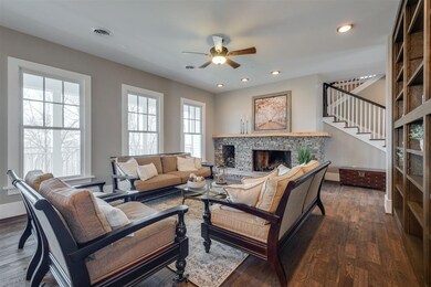The hardwood floors gracefully carry into the main living area.  Notice the large windows which allow lots of natural light to flow into the room.