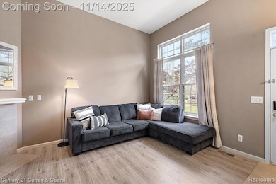 Living room with bright window, updated flooring, new paint, and fireplace