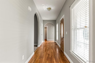 Hallway with arched walkways, wood finished floors