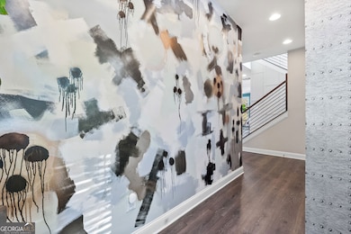 Hallway from Foyer to main living space with custom artwork and modern stair rail