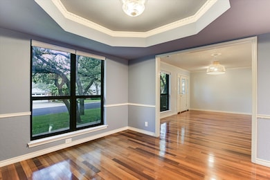 Unfurnished room featuring crown molding, a tray ceiling, hardwood / wood-style floors, and a chandelier