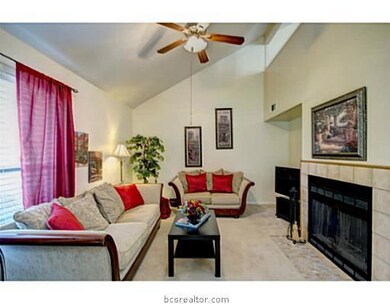 Living Room. Creating a warm environment, this carpeted living room exhibits an oversized window and a fireplace with tile detailing.
