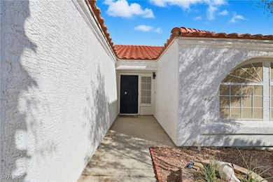 View of exterior entry featuring stucco siding and a tiled roof