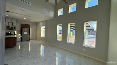Unfurnished living room featuring light tile floors, a notable chandelier, and a healthy amount of sunlight
