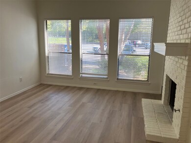 Unfurnished living room featuring light wood-type flooring and a brick fireplace