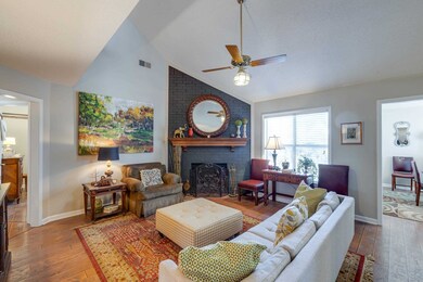 Living area with visible vents, baseboards, a bric