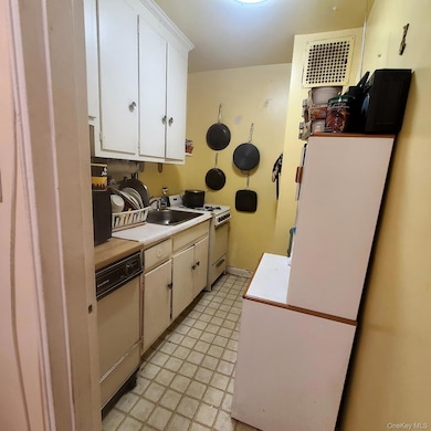 Kitchen with white appliances, white cabinets, and light countertops