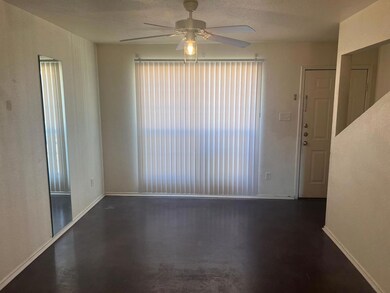 Spare room featuring ceiling fan, plenty of natural light, finished concrete flooring, and a textured ceiling