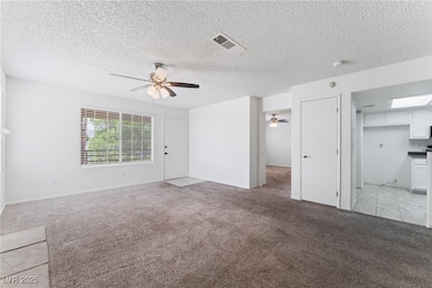 Unfurnished living room with light colored carpet and a textured ceiling