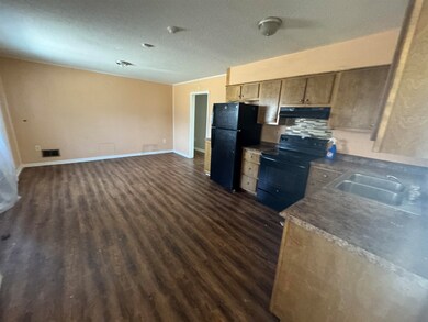 Kitchen featuring baseboards, dark wood-style floo