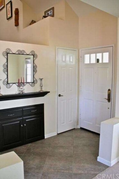 Vaulted ceiling and slate-style tile entry with un