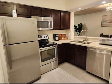 Kitchen with light countertops, appliances with st