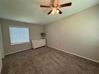 Empty room with dark carpet and ceiling fan