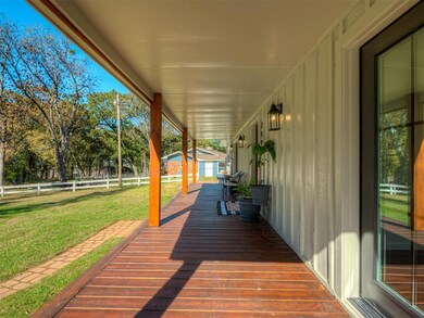 Wooden porch featuring an outdoor structure and view of wooded area