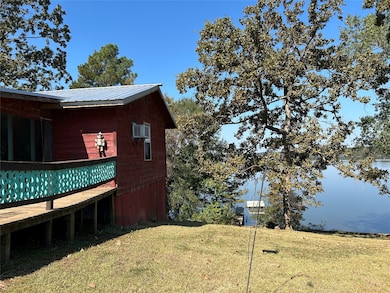 View of home's exterior featuring a metal roof, a yard, and a water view