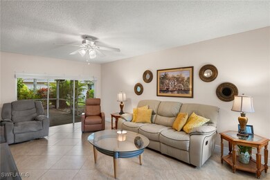 Tiled living room with ceiling fan and a textured