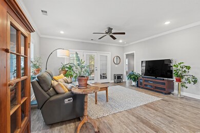 Living area featuring baseboards, visible vents, wood finished floors, and french doors