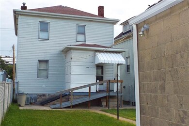Rear view of home with covered rear porch and leve
