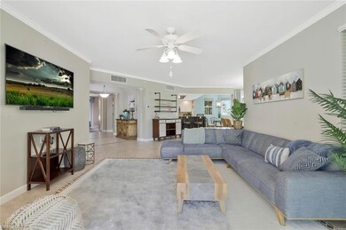 Living area with ornamental molding, a ceiling fan, and baseboards