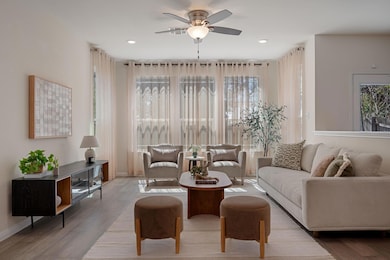 Living area featuring a ceiling fan, baseboards, 