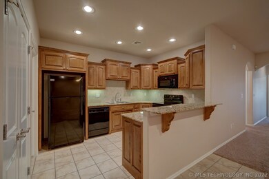 Kitchen features granite counters, gas stove, dish