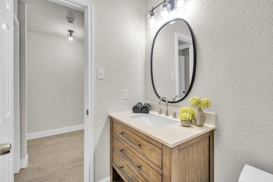 Half bath with vanity and wood finished floors