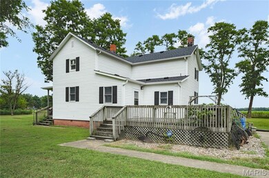 Back of house with a wooden deck, a yard, a chimney, and stairway