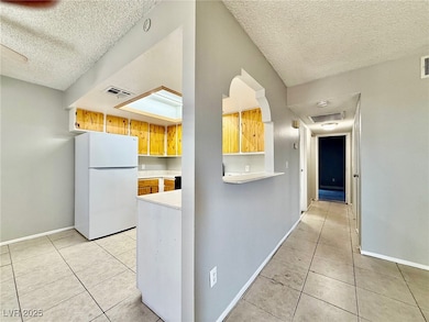 Kitchen featuring freestanding refrigerator, a tex