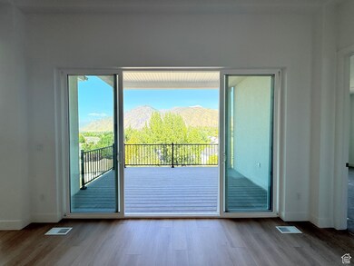 Doorway to outside with a mountain view, plenty of natural light, and wood finished floors