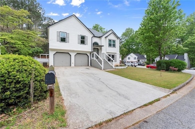 Bi-level home with concrete driveway, a front yard