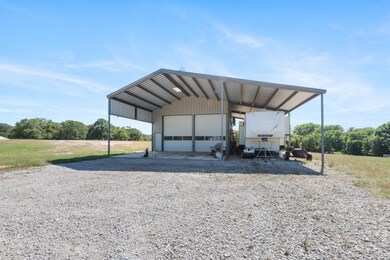 View of shop with roll up doors and large space for camper or vehicle parking