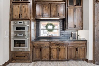 Kitchen featuring double oven, decorative backspla