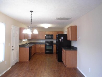 Kitchen has abundance of cabinets, nice black appliances remain and an eating area!