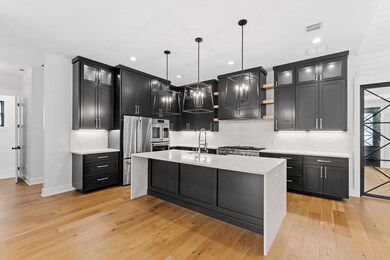 Kitchen featuring wall chimney range hood, light 