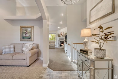 Living area with carpet floors, recessed lighting, and a stone fireplace