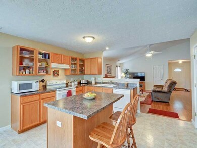 Kitchen. Kitchen with glass cabinets and view of great room. Center island with seating.
