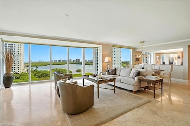 Living room featuring expansive windows, a water view, ornamental molding, and a view of Clam Bay