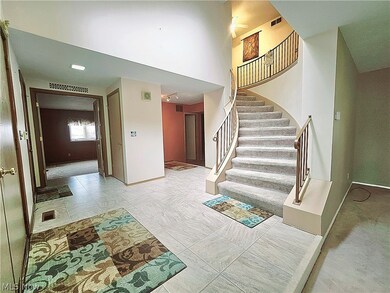 Staircase featuring a high ceiling and light tile floors
