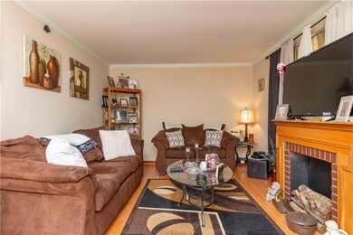 Living room with ornamental molding, light hardwoo