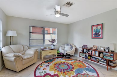 Sitting room featuring ceiling fan and light tile 