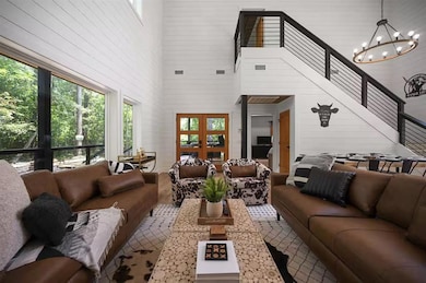 Living room with a high ceiling, an inviting chand