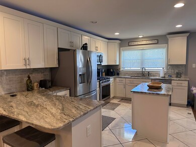 Kitchen featuring light stone countertops, a penin