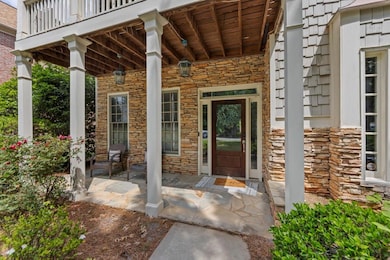 View of exterior entry with stone siding and a por