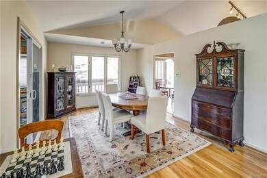 Dining room has hardwood floors, vaulted ceiling a