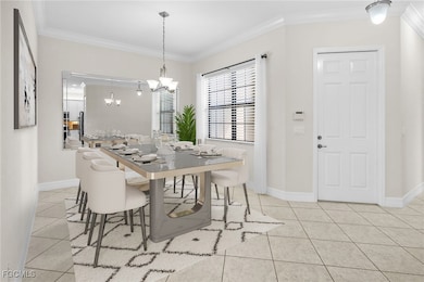 Dining area with crown molding, light tile patterned flooring, and a chandelier